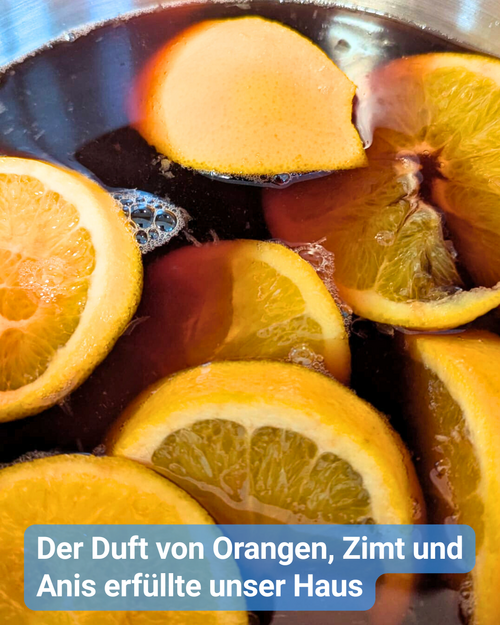 Ein Topf mit selbstgemachtem Weihnachtspunsch, in dem mehrere Orangenscheiben schwimmen. Die Flüssigkeit ist rot und leicht schimmernd, kleine Bläschen steigen an die Oberfläche. Das Bild vermittelt den warmen Duft von Orangen, Zimt und Anis während der Punschzubereitung im Pflegekompetenzzentrum.